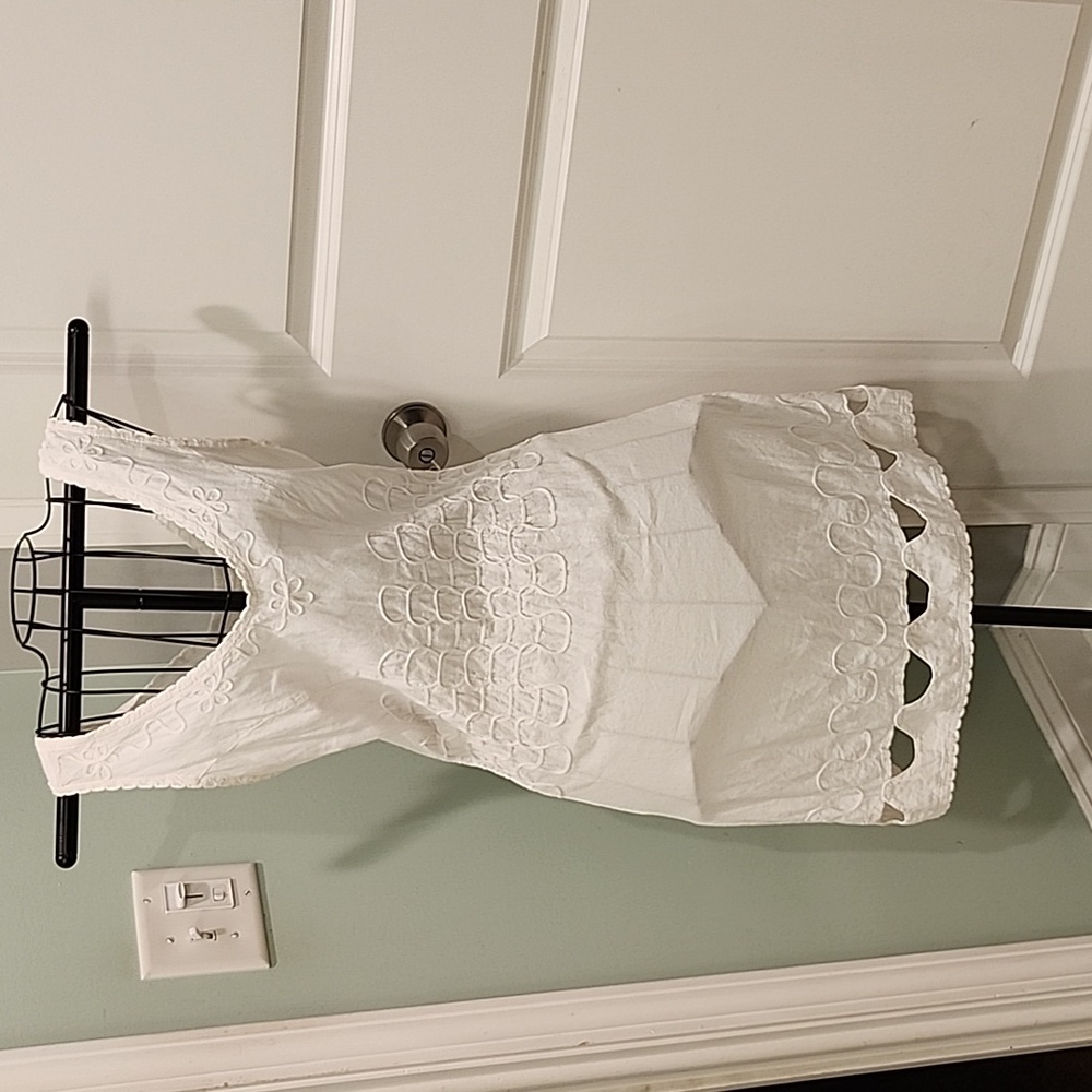White mid length dress with embroidered details.